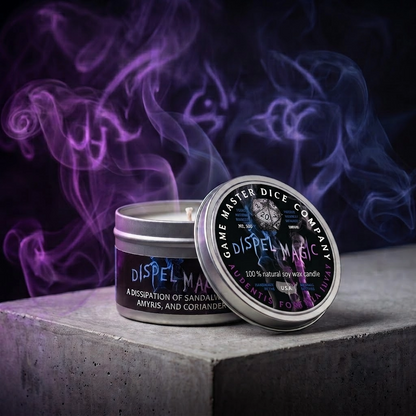 A silver tin of 'Dispel Magic' scented wax candle by The Game Master Dice Company, shown with its lid leaning against the front. The candle is set on a gray concrete block with dramatic purple and blue smoke swirling in the background against a dark backdrop.
